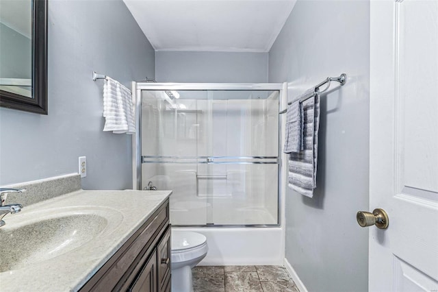 full bathroom featuring toilet, vanity, baseboards, and shower / bath combination with glass door