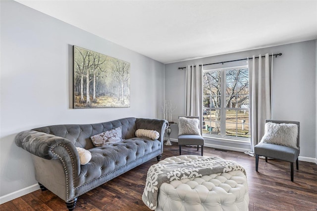 living area with baseboards and wood finished floors