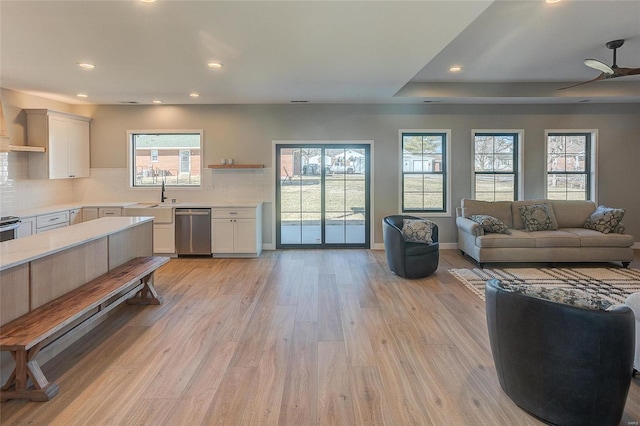 living area featuring light wood-style floors, recessed lighting, baseboards, and a ceiling fan