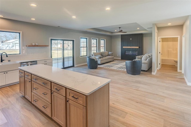 kitchen featuring a large fireplace, a healthy amount of sunlight, and light wood-style floors