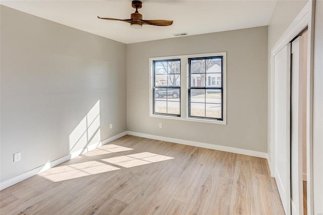 unfurnished bedroom with light wood-style flooring, visible vents, a ceiling fan, baseboards, and a closet