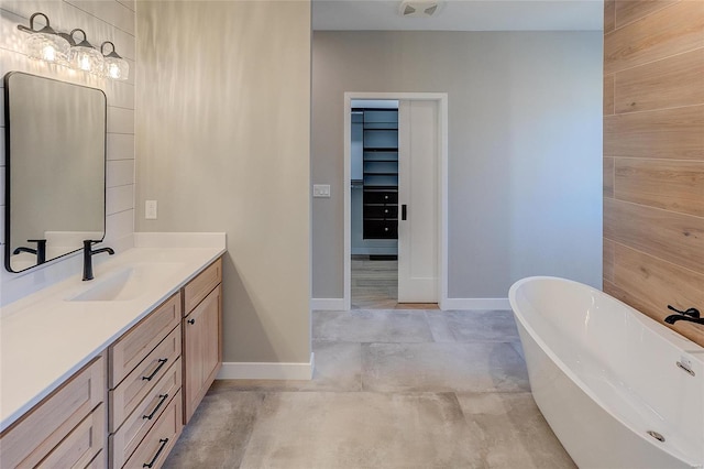 full bath featuring visible vents, baseboards, vanity, concrete flooring, and a freestanding bath