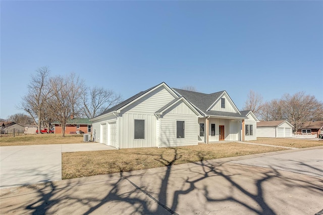 modern inspired farmhouse featuring central air condition unit, a porch, an attached garage, board and batten siding, and driveway