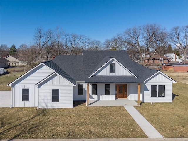 modern inspired farmhouse with covered porch, a shingled roof, a front lawn, and board and batten siding