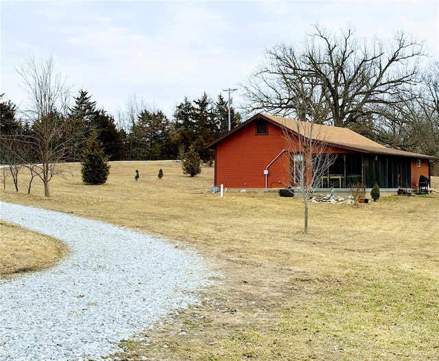 view of yard featuring a sunroom and driveway