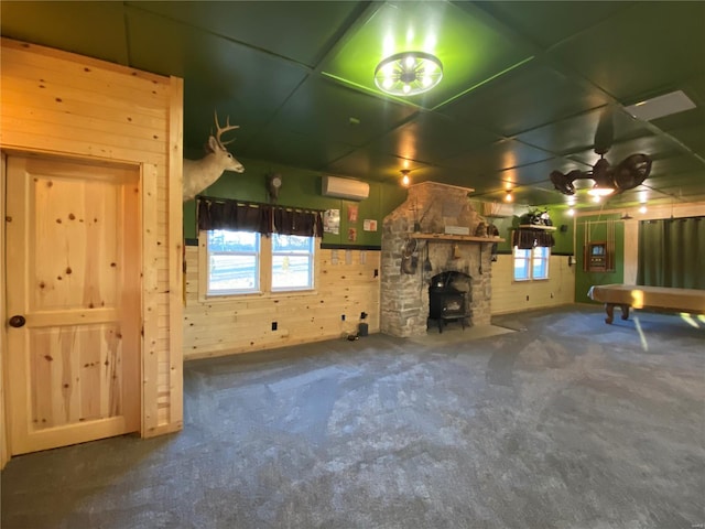 unfurnished living room with carpet floors, wood walls, and a wall mounted AC