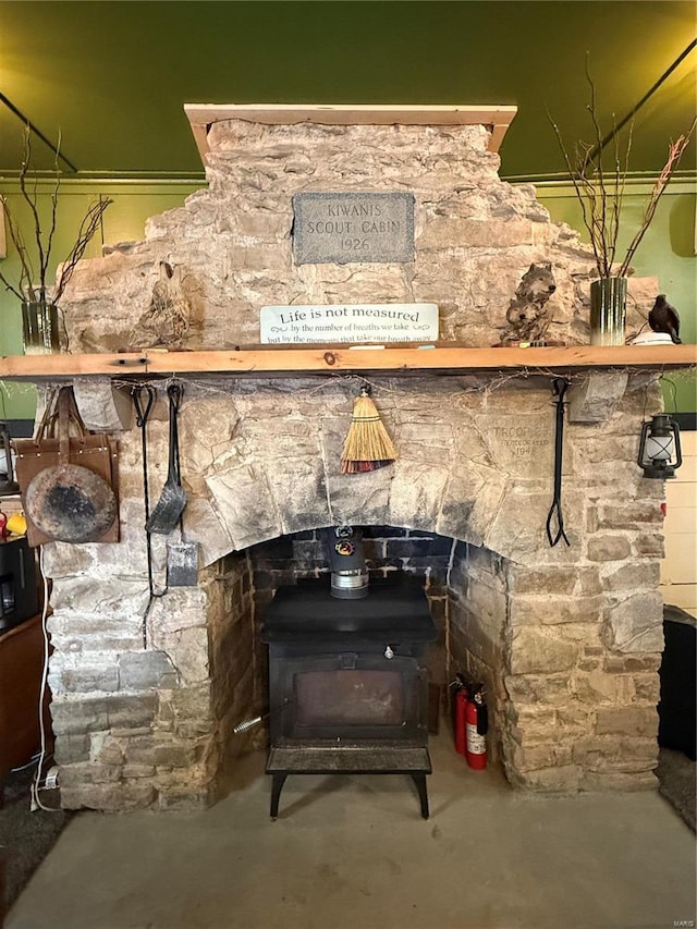 room details with concrete flooring, a wood stove, and a fire extinguisher