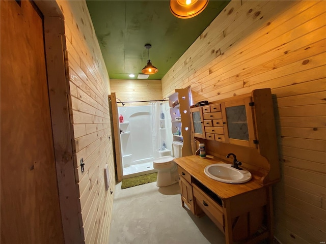 bathroom featuring wooden walls, toilet, concrete flooring, vanity, and a shower stall