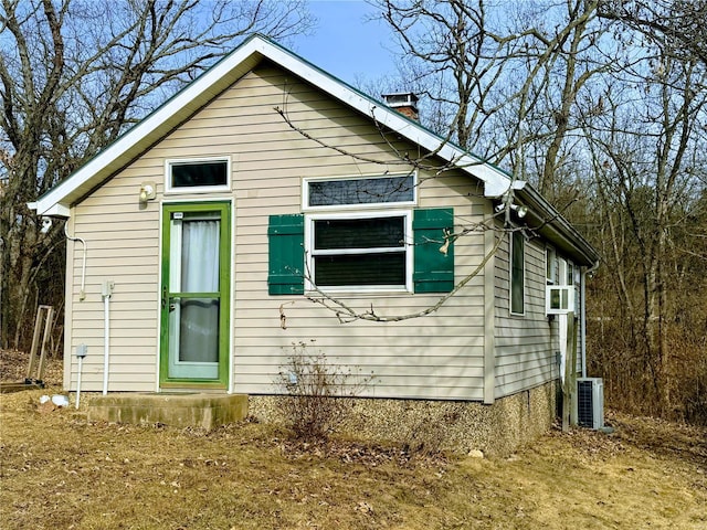 exterior space featuring a chimney and central AC unit