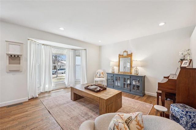 living room featuring visible vents, recessed lighting, baseboards, and light wood-style floors