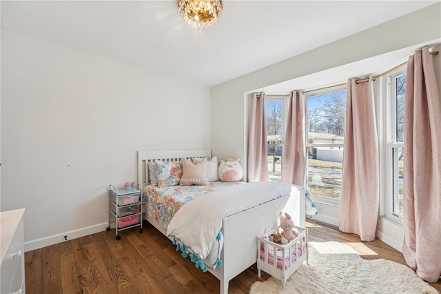 bedroom featuring multiple windows, wood finished floors, and baseboards