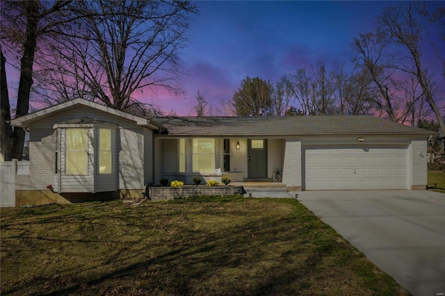 view of front of home featuring an attached garage, a lawn, brick siding, and driveway