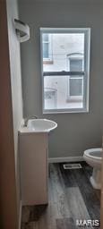 bathroom featuring toilet, baseboards, wood finished floors, and vanity