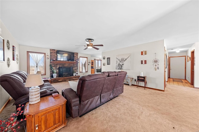 living area featuring a ceiling fan, baseboards, light colored carpet, and a fireplace