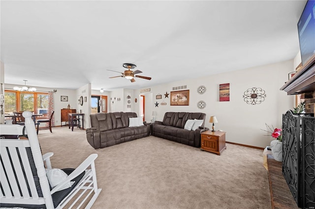 living room with visible vents, baseboards, carpet flooring, ceiling fan with notable chandelier, and a fireplace