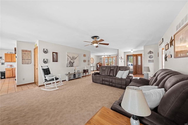 living area with light tile patterned floors, a ceiling fan, baseboards, visible vents, and light carpet