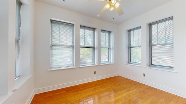 unfurnished room with light wood-style flooring, baseboards, and ceiling fan