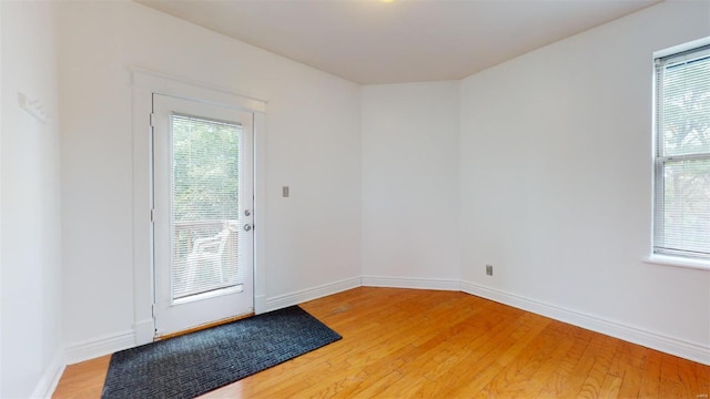 doorway featuring light wood-style floors and baseboards