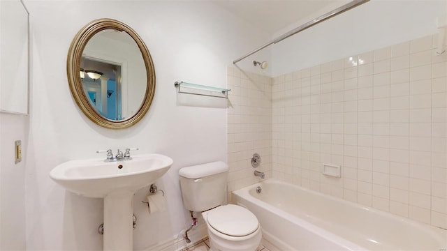 bathroom featuring bathing tub / shower combination, toilet, and a sink