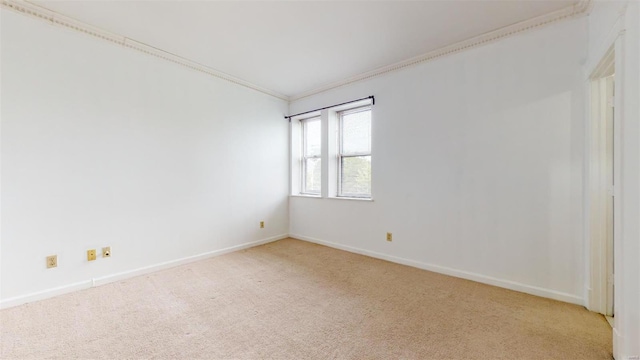 empty room featuring baseboards, light carpet, and ornamental molding