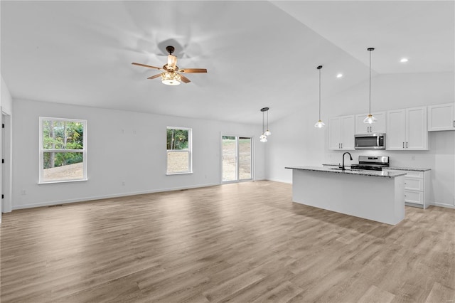 kitchen featuring appliances with stainless steel finishes, open floor plan, white cabinetry, and ceiling fan