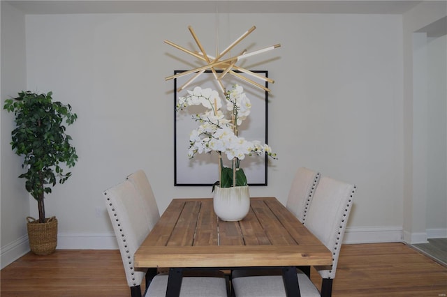 dining space featuring baseboards and wood finished floors