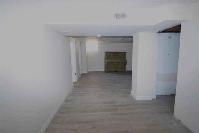 corridor featuring light wood-style floors, visible vents, and baseboards