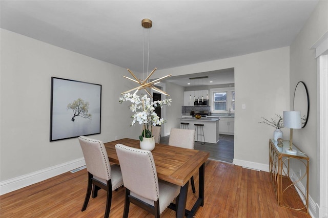 dining space featuring light wood-style floors and baseboards