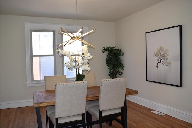 dining room featuring a wealth of natural light, visible vents, and wood finished floors