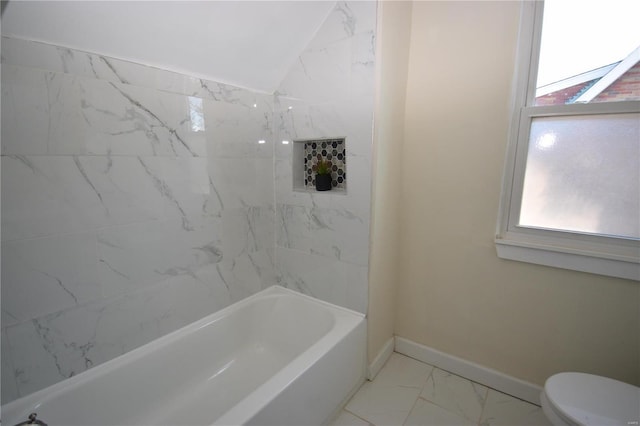 bathroom featuring toilet, a healthy amount of sunlight, marble finish floor, and baseboards