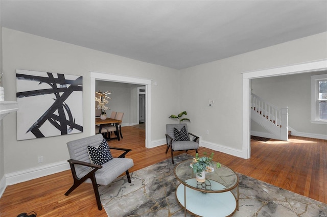 sitting room featuring stairway, wood finished floors, and baseboards