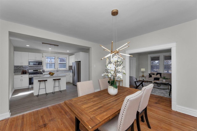 dining area featuring light wood-type flooring and baseboards