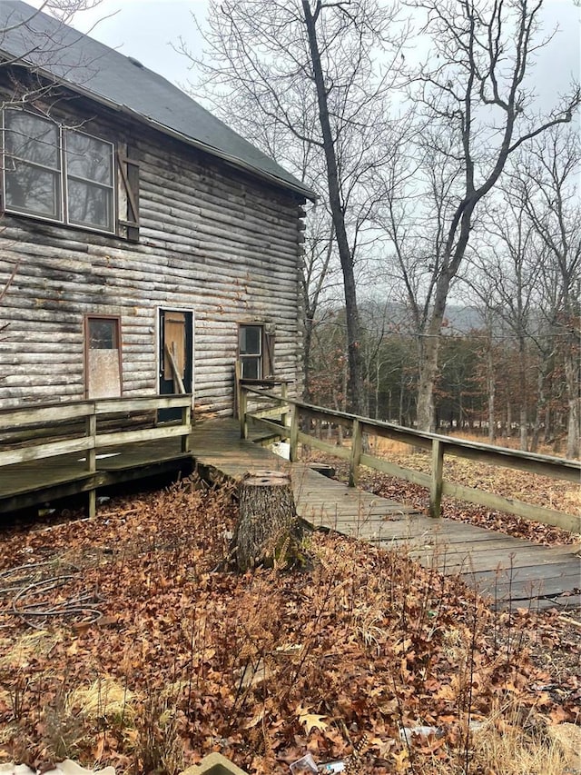 view of property exterior featuring fence and a wooden deck