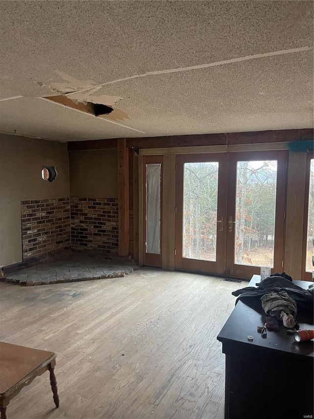 living room featuring french doors, a textured ceiling, and wood finished floors