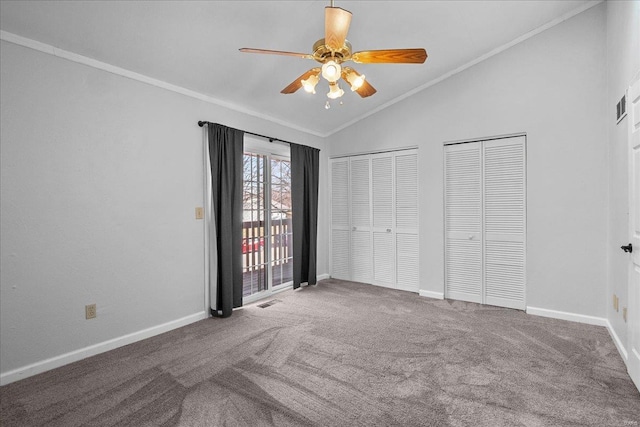 unfurnished bedroom featuring baseboards, ornamental molding, vaulted ceiling, and two closets