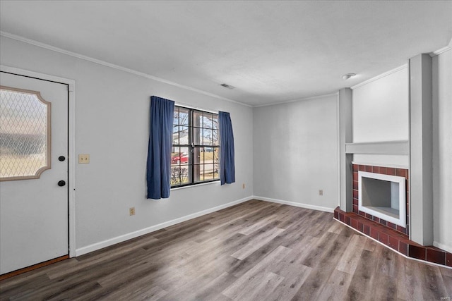 unfurnished living room featuring baseboards, ornamental molding, wood finished floors, and a tile fireplace