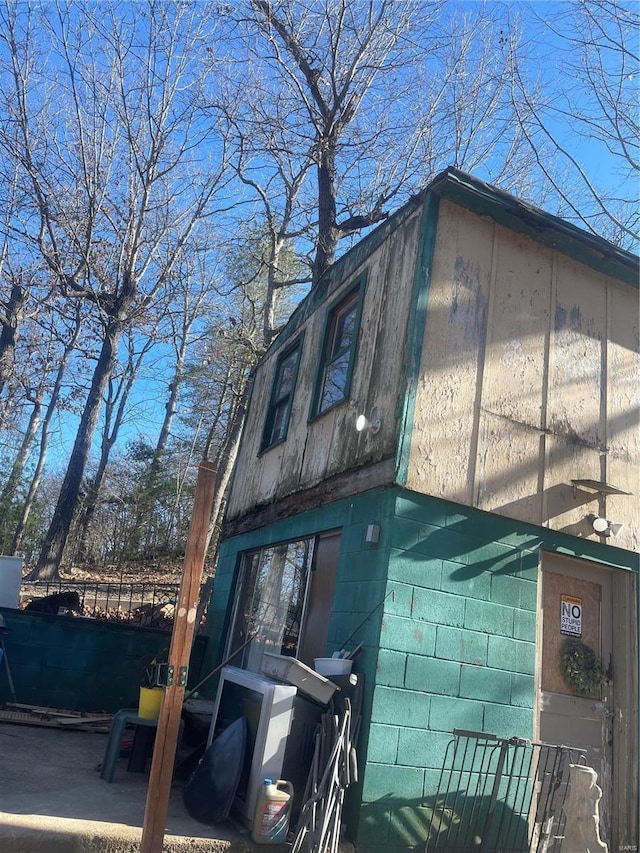 view of home's exterior featuring fence and concrete block siding