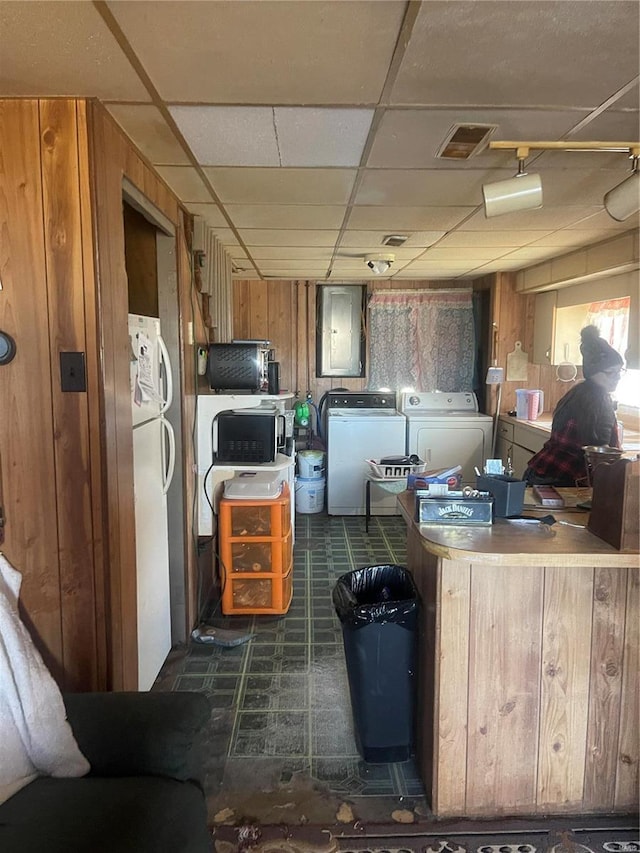 kitchen with a paneled ceiling, visible vents, wood walls, electric panel, and tile patterned floors