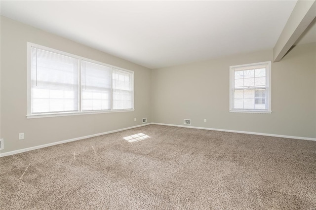 carpeted spare room featuring baseboards