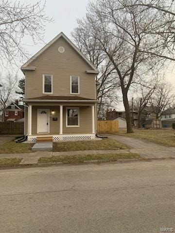 view of front of property featuring covered porch and fence