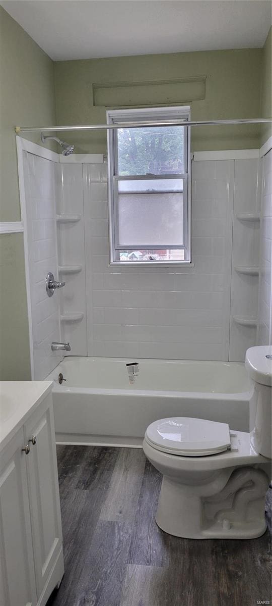 bathroom featuring toilet, shower / bath combination, wood finished floors, and vanity