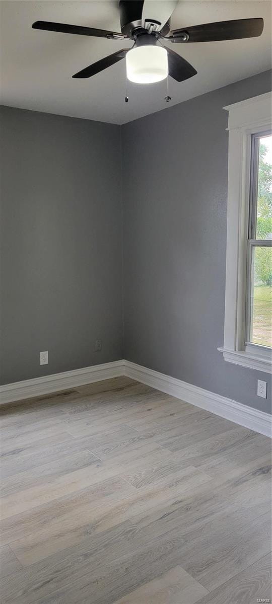 spare room with baseboards, a ceiling fan, and wood finished floors