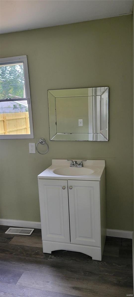 bathroom featuring wood finished floors, vanity, baseboards, and visible vents