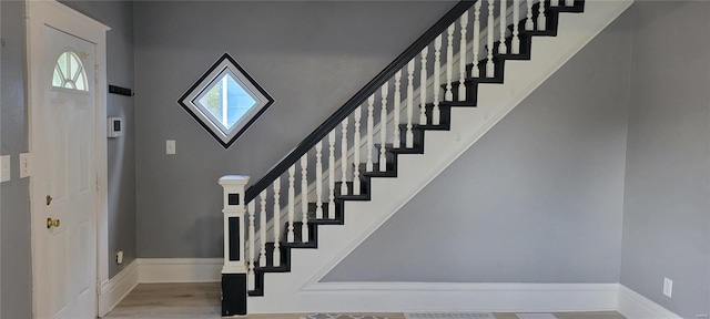 stairway with wood finished floors and baseboards