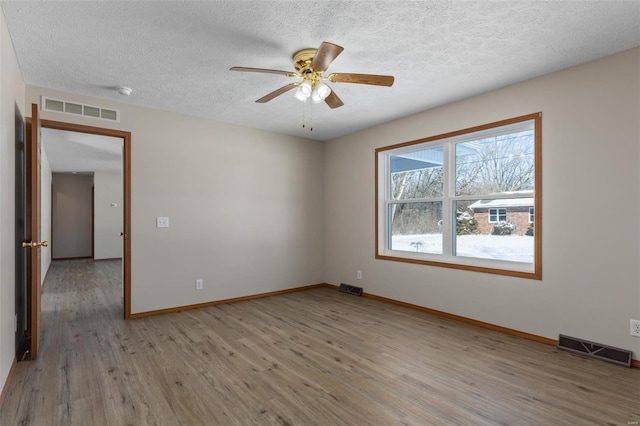 unfurnished room with light wood-style floors and visible vents