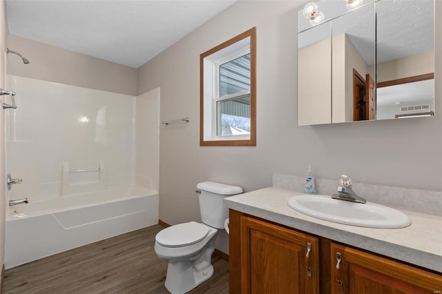 full bathroom with toilet, wood finished floors, visible vents, vanity, and  shower combination