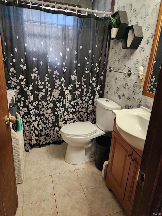 bathroom featuring a shower with curtain, toilet, vanity, tile patterned flooring, and wallpapered walls