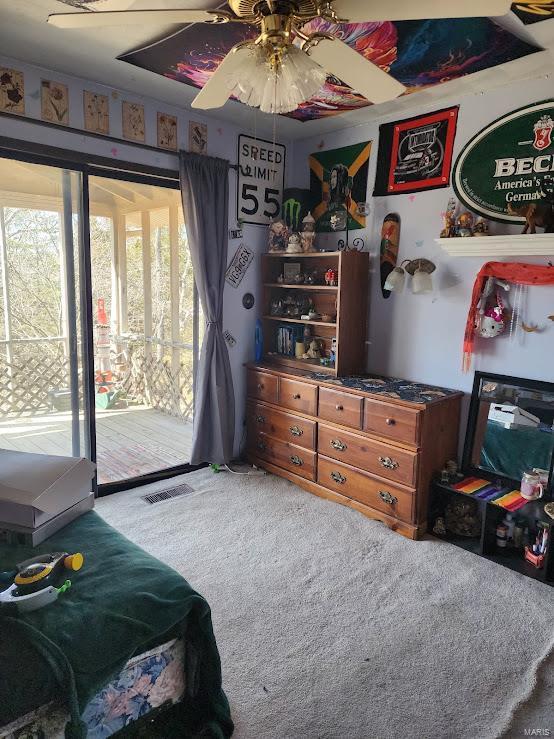 carpeted bedroom featuring access to outside, visible vents, and ceiling fan