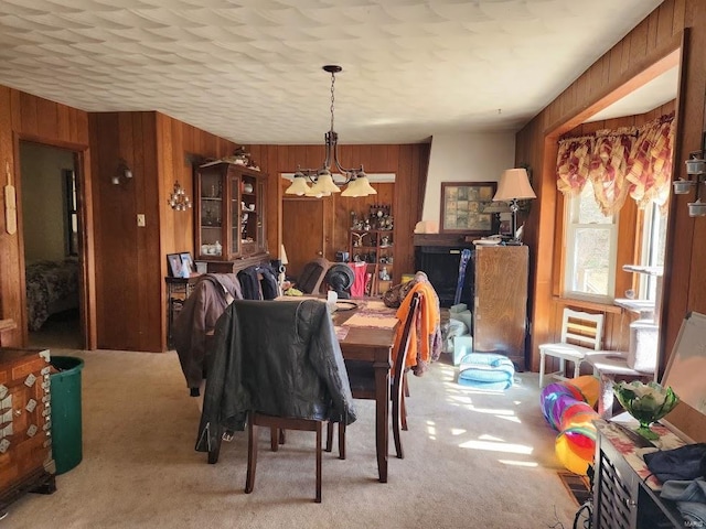 carpeted dining area featuring wood walls