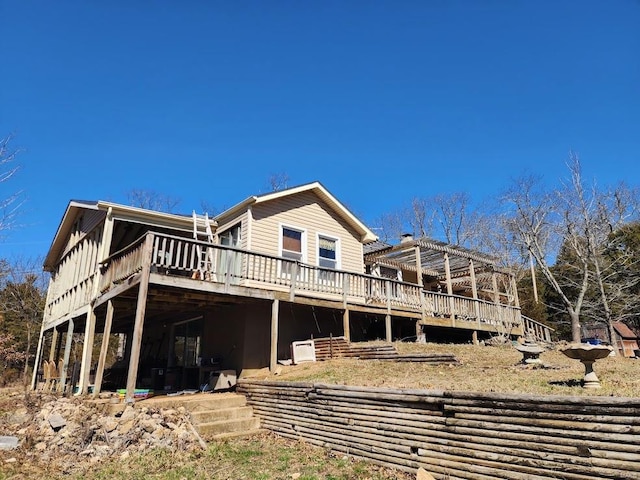 rear view of house with a wooden deck and a pergola